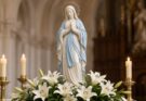 Statue of Mary Immaculate surrounded by white lilies and candles